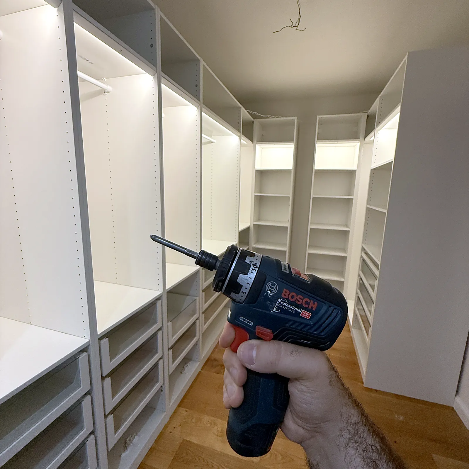 Akkuschrauber vor einem neu aufgebauten begehbaren Kleiderschrank