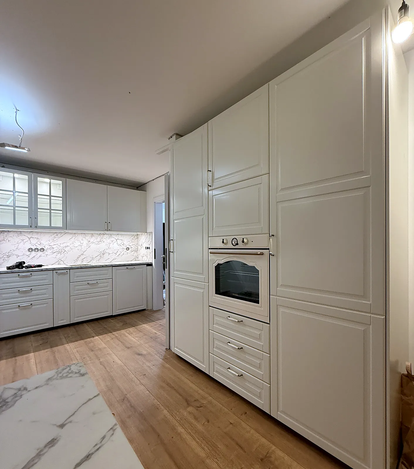Landhausküche mit Hochschränken und Einbaubackofen