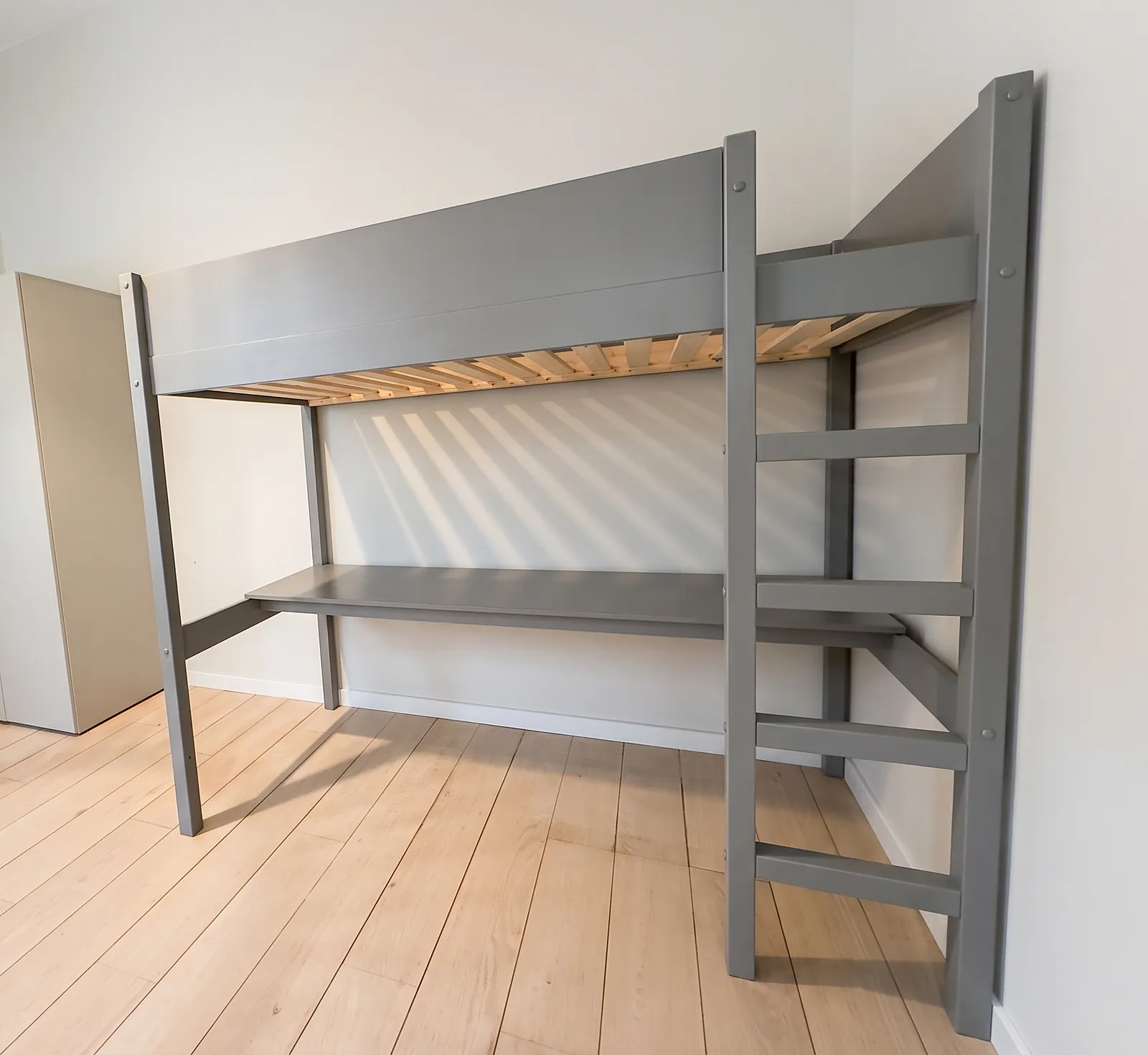 Graues Hochbett mit Schreibtisch und Leiter